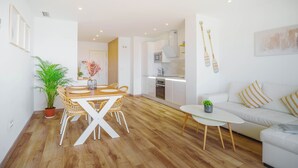 A modern apartment with a dining area, kitchen, and living room. - Marbella Beach Front View by Sol Maestranza (Marbella)