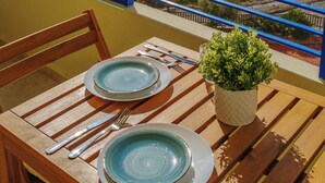 A table set with plates and cutlery, overlooking a beach with a view of the ocean. - Marbella Beach Front View by Sol Maestranza (Marbella)