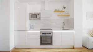 A modern kitchen with white cabinetry, a built-in microwave, a stainless steel oven, and a sink with a faucet. - Marbella Beach Front View by Sol Maestranza (Marbella)