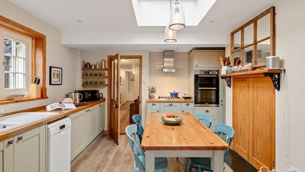 A kitchen with a wooden table, chairs, and a skylight. - Aldeburgh - spacious 3 bed period house on High St (Aldeburgh)