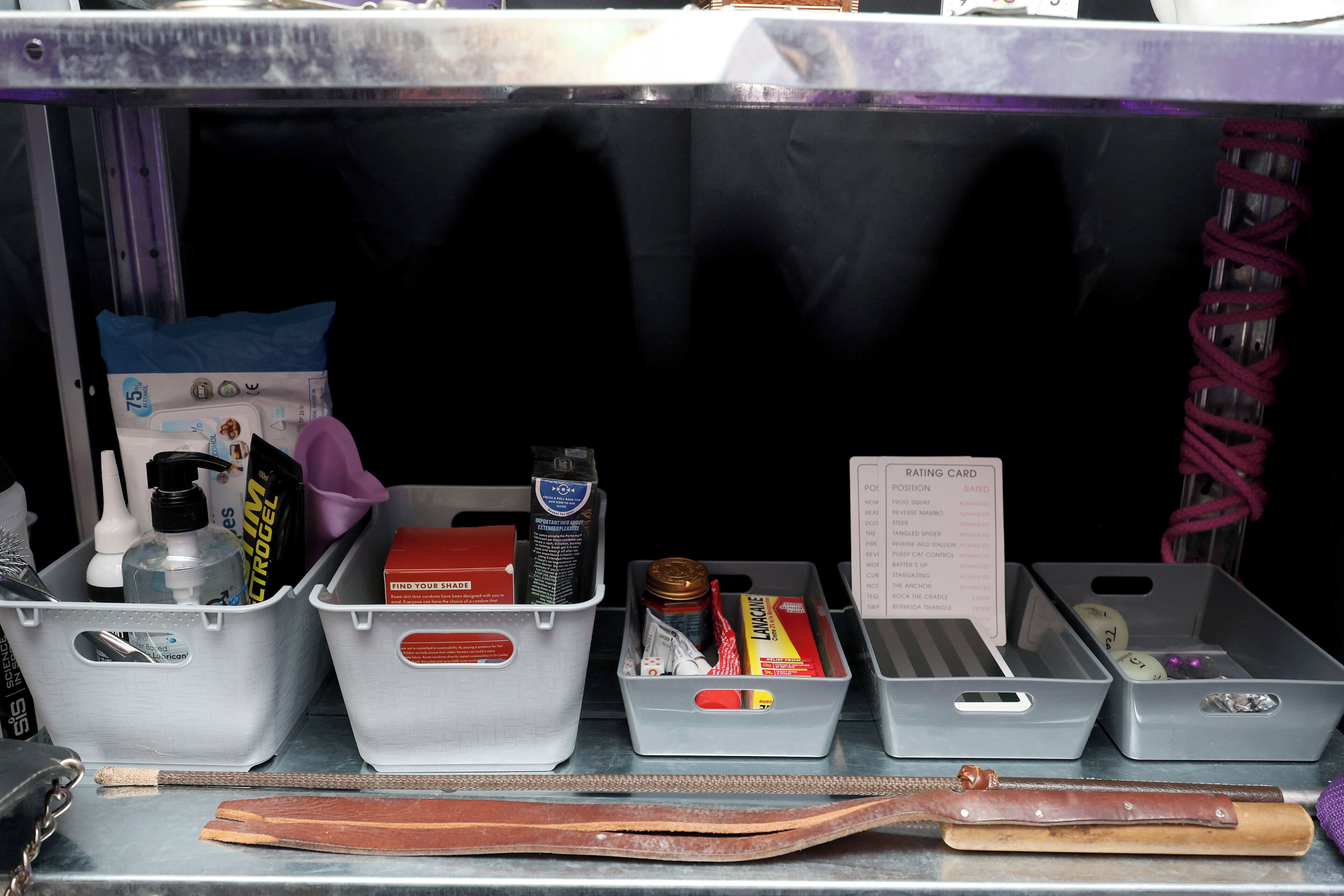 A storage area with various items including a red box labeled 'FIND YOUR SHAPE,' a bottle of hand sanitizer, and a 'Rating Card' with positions and their ratings.