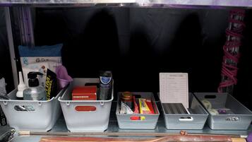 A storage area with various items including a red box labeled 'FIND YOUR SHAPE,' a bottle of hand sanitizer, and a 'Rating Card' with positions and their ratings.
