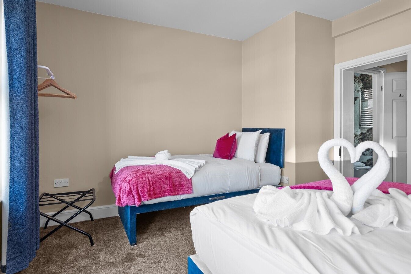 A hotel room with a bed, a chair, and a wardrobe.