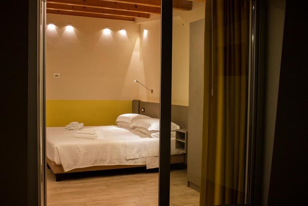 A bedroom with a bed, a bedside table, and a nightstand.
