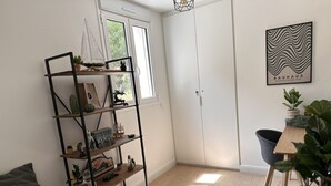 Una stanza con un letto, una libreria, una scrivania, una sedia, una porta e una finestra.