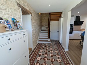 Ein Korridor mit einem gemusterten Boden, der zu einer Treppe führt.