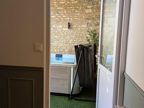 A bathroom with a stone wall, a sink, and a shower area. - Renovated Charente house, countryside view - guests (MAINE DE BOIXE)