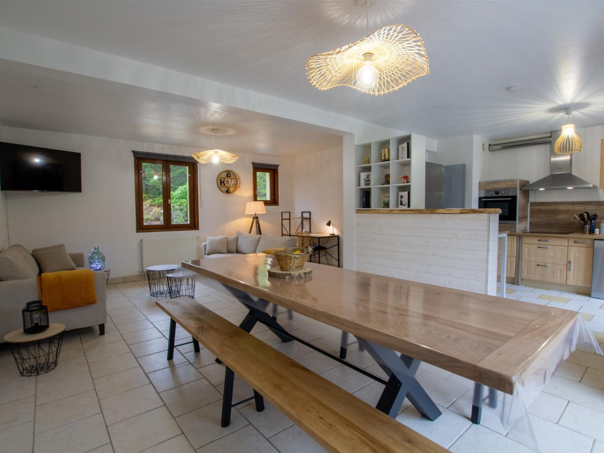 Una cocina moderna con una isla grande, estanterías empotradas y un comedor con banco.