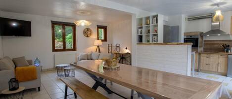 Una cocina moderna con una isla grande, estanterías empotradas y un comedor con banco.