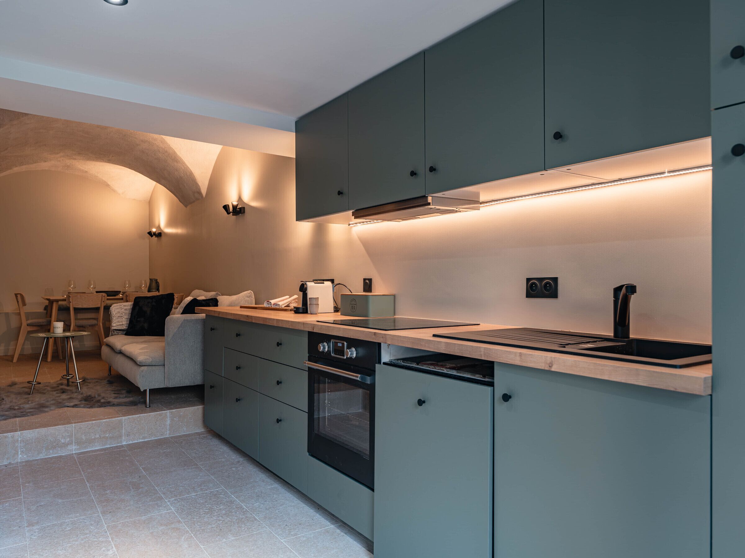 A modern kitchen with built-in appliances, a dining area with a table and chairs, and a cozy seating area.