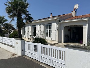 A two-story building with a white facade, a satellite dish, and a garage entrance. - Spacious and tranquil house - 5 guests (Givrand)