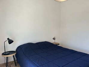 A bedroom with a bed, a round side table, and two floor lamps. - Spacious and tranquil house - 5 guests (Givrand)