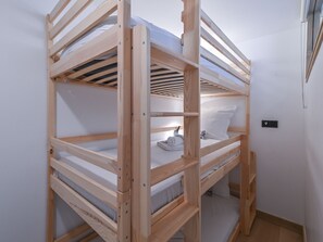 A bunk bed with a wooden frame, a white mattress, and a pillow. - Elegant apartment, panoramic view, mountain - 7 guests (Huez)