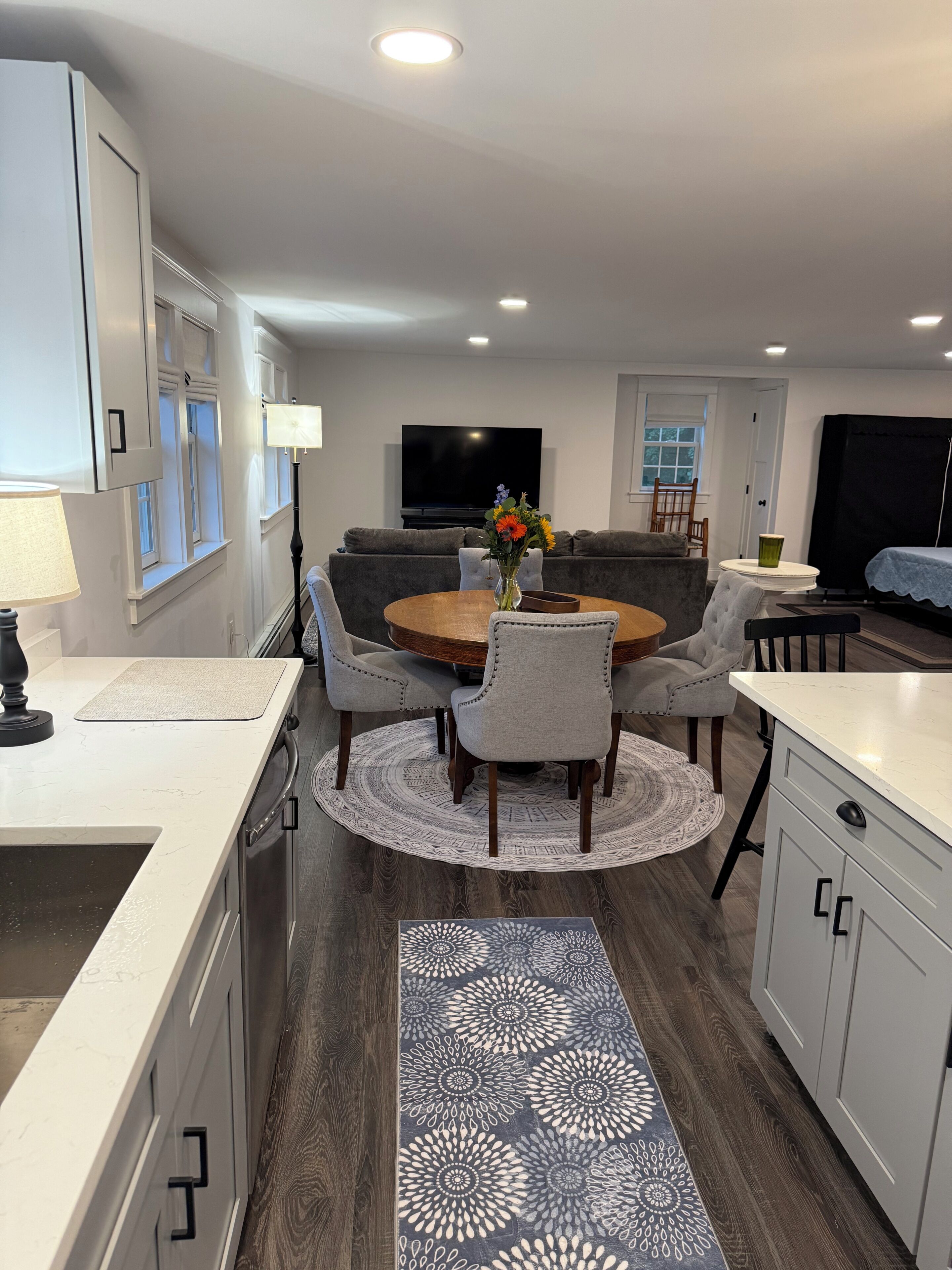 Una cocina moderna con comedor, televisor de pantalla plana y sofá.