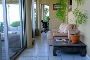Ein Wohnzimmer mit einer Couch, einem Couchtisch und einer Topfpflanze.