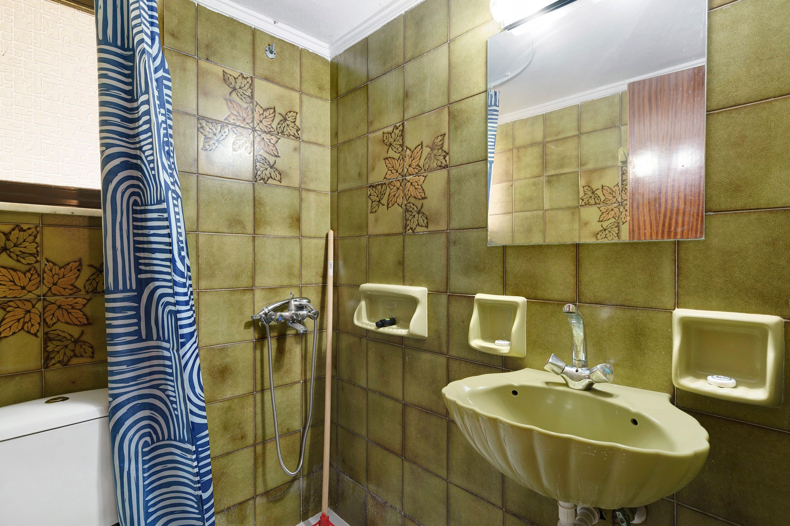 A bathroom with a shower, a sink, and a mirror.