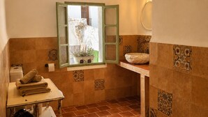 Un bagno con finestra, lavandino e porta asciugamani.