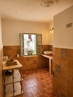 Une salle de bain avec une fenêtre, un lavabo et un porte-serviettes.