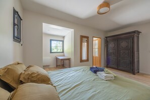 A bedroom with a bed, a wooden wardrobe, a small table, and a window. - A charming home on the hills above Trouville (Trouville-sur-Mer)