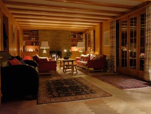 A cozy living room with a fireplace, bookshelves, and comfortable seating. - Lill Britta 2, mittlere Wohunug Appartement/Fewo, Dusche und Bad, WC, Komfort by Interhome (Arosa)