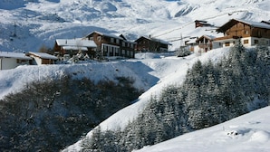 A snow-covered mountain village with wooden buildings and a ski lift. - Lill Britta 2, mittlere Wohunug Appartement/Fewo, Dusche und Bad, WC, Komfort by Interhome (Arosa)