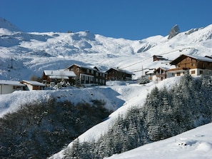 A snow-covered mountain village with wooden buildings and a ski lift. - Lill Britta 2, mittlere Wohunug Appartement/Fewo, Dusche und Bad, WC, Komfort by Interhome (Arosa)