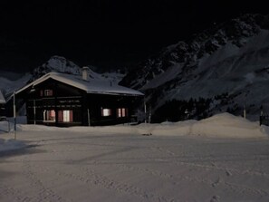A snow-covered mountain lodge with a dark facade and visible windows. - Lill Britta 2, mittlere Wohunug Appartement/Fewo, Dusche und Bad, WC, Komfort by Interhome (Arosa)