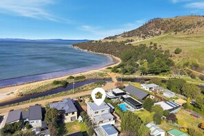 A coastal residential area with houses, a swimming pool, and a beach. - Seven Mile Beach Holiday Home - unwind and restore (Seven Mile Beach)