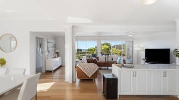 A modern living space with a dining area, kitchen, and a balcony with a view.