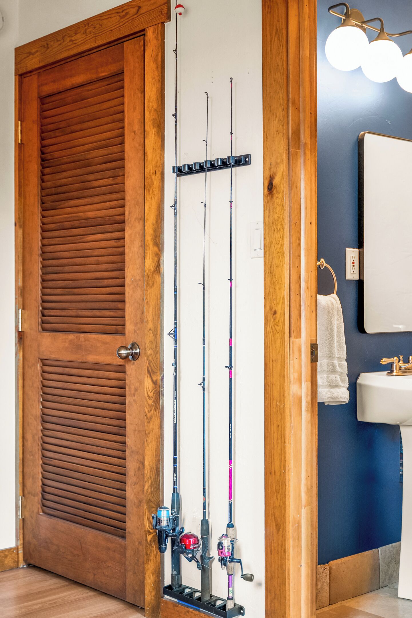 Une porte en bois, avec un porte-cannes vertical fixé au mur à côté.