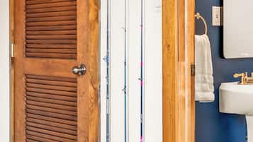 Une porte en bois, avec un porte-cannes vertical fixé au mur à côté.