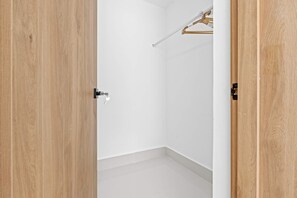A room with a wooden door, a white wall, and a hanging clothes rack. - NOK Elegant 3BR Villa With Private Pool (Punta Cana)
