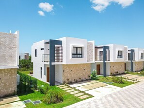 A modern residential complex with multiple two-story houses, each featuring a balcony and a small garden area. - NOK Elegant 3BR Villa With Private Pool (Punta Cana)
