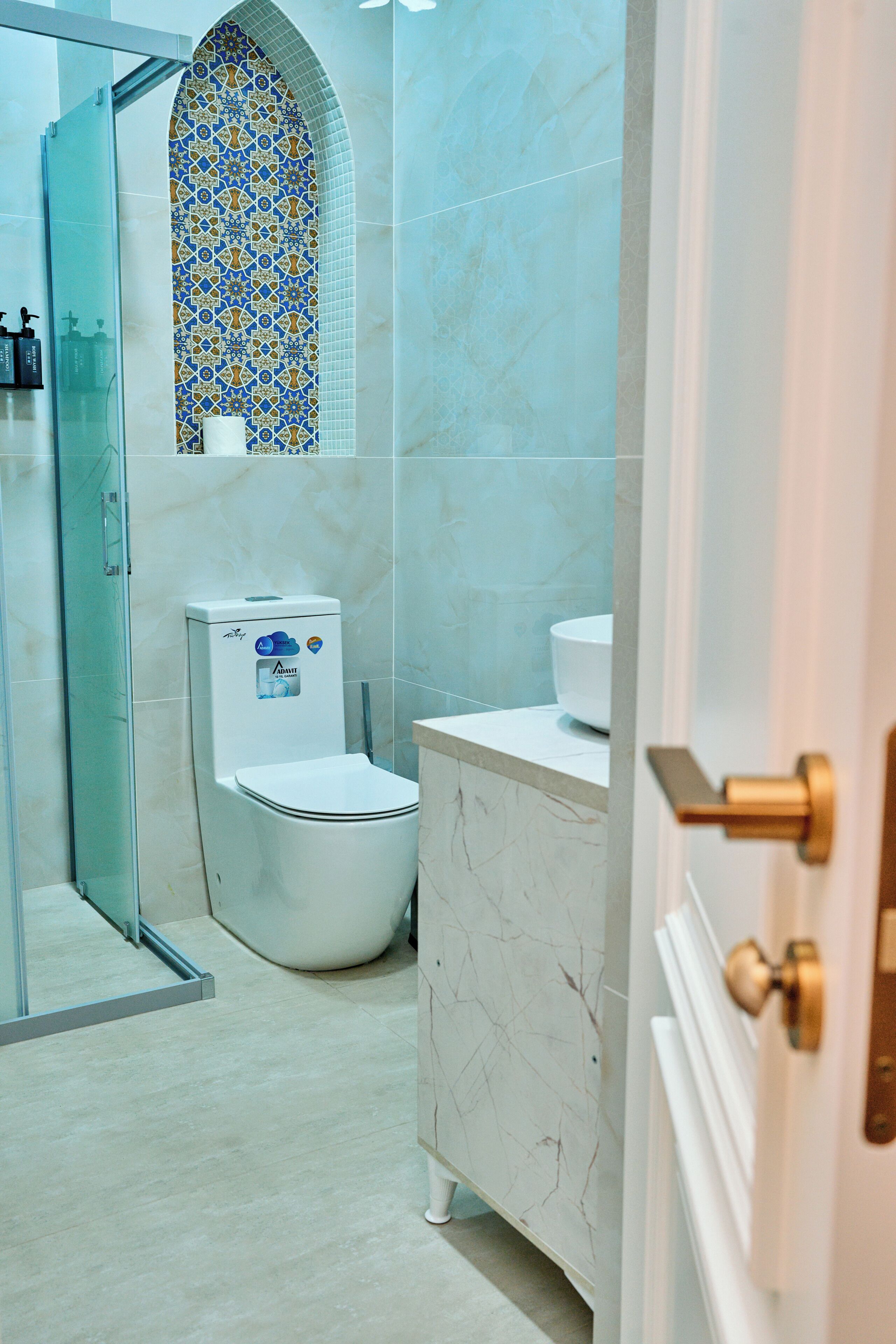A bathroom with a toilet, a sink, and a shower area.