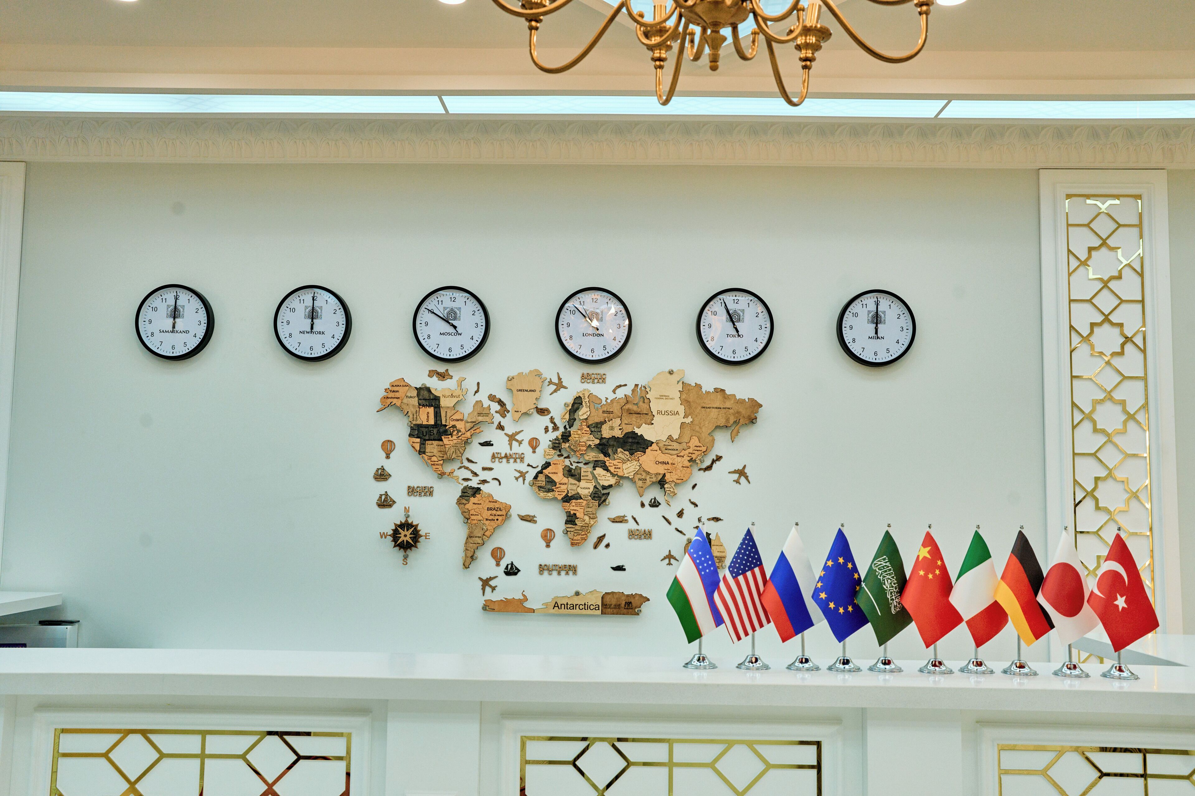 A wall with clocks displaying different cities, a world map, and a row of national flags.
