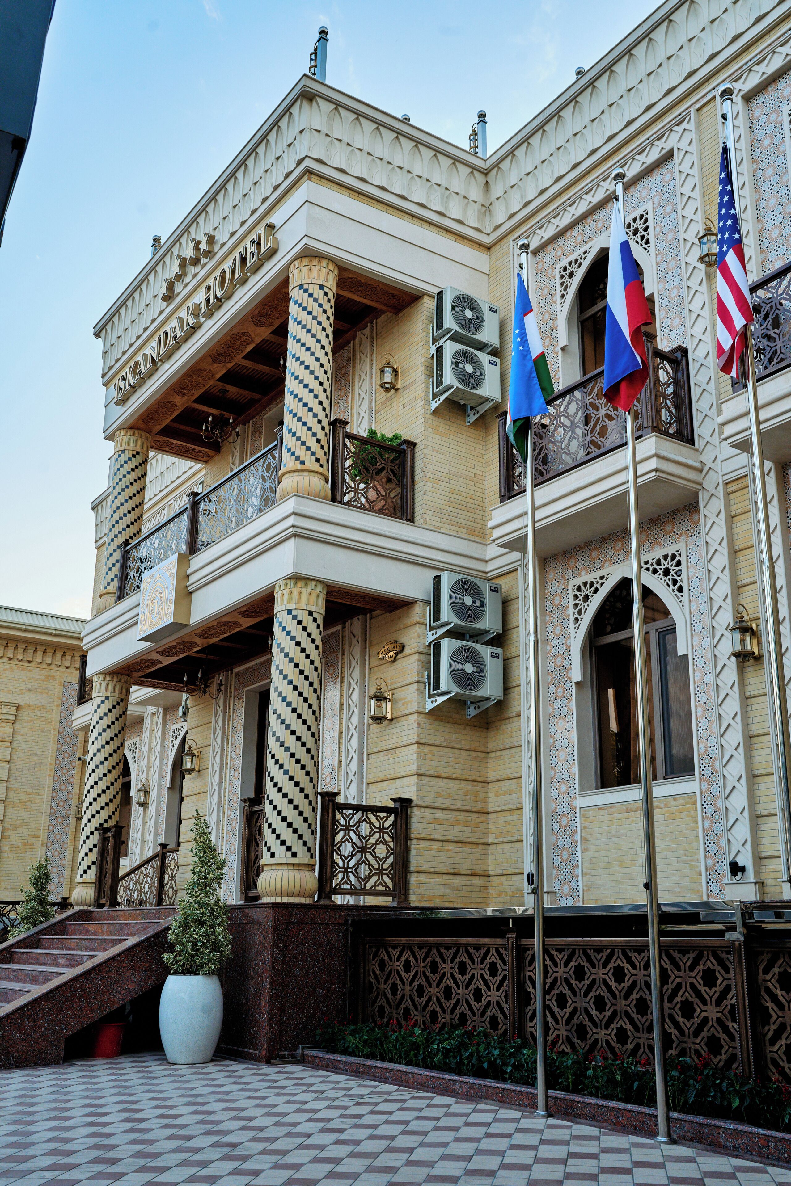 Um hotel com estilo arquitetônico tradicional, com varandas elaboradas e colunas decorativas.