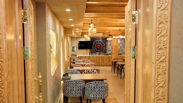 Um restaurante com decoração em madeira, cadeiras estampadas e um balcão comprido.