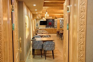 Un restaurante con decoración de madera, sillas estampadas y una larga barra.