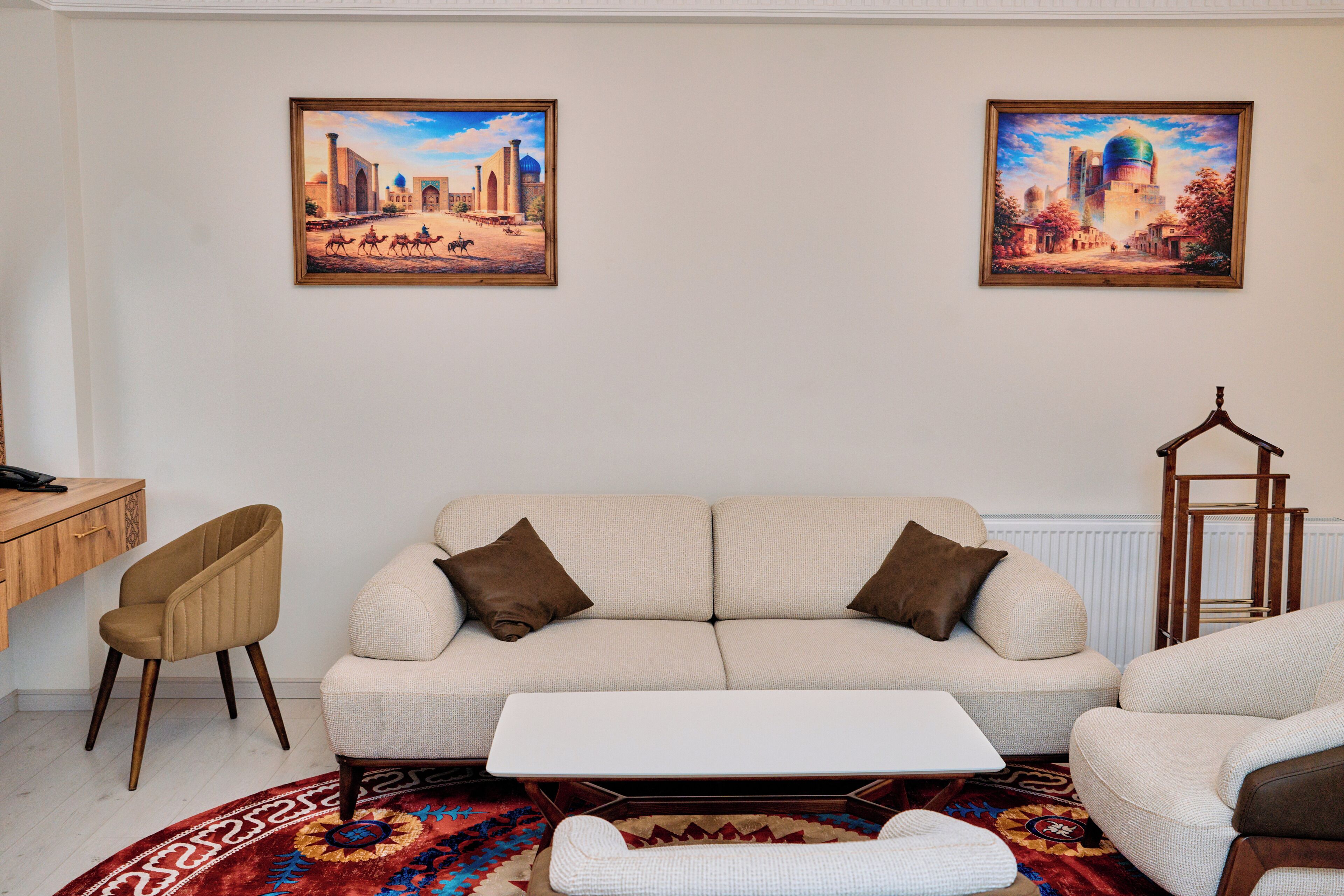 A living room with a sofa, a coffee table, a chair, and two framed pictures on the wall.