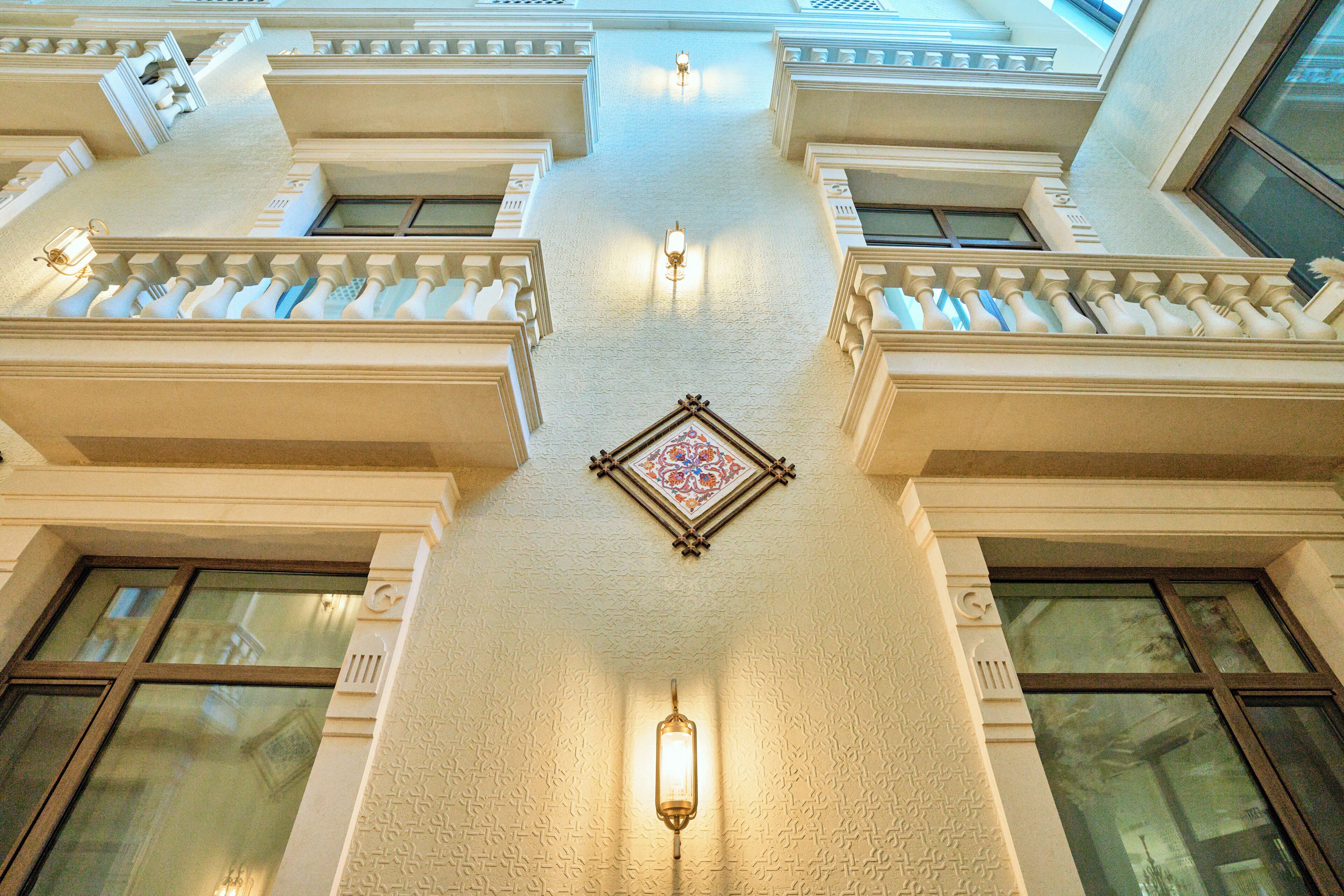 A building's interior with a central decorative element, multiple windows, and a patterned ceiling.