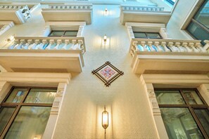 A building's interior with a central decorative element, multiple windows, and a patterned ceiling. - ISKANDAR Hotel (Samarkand)
