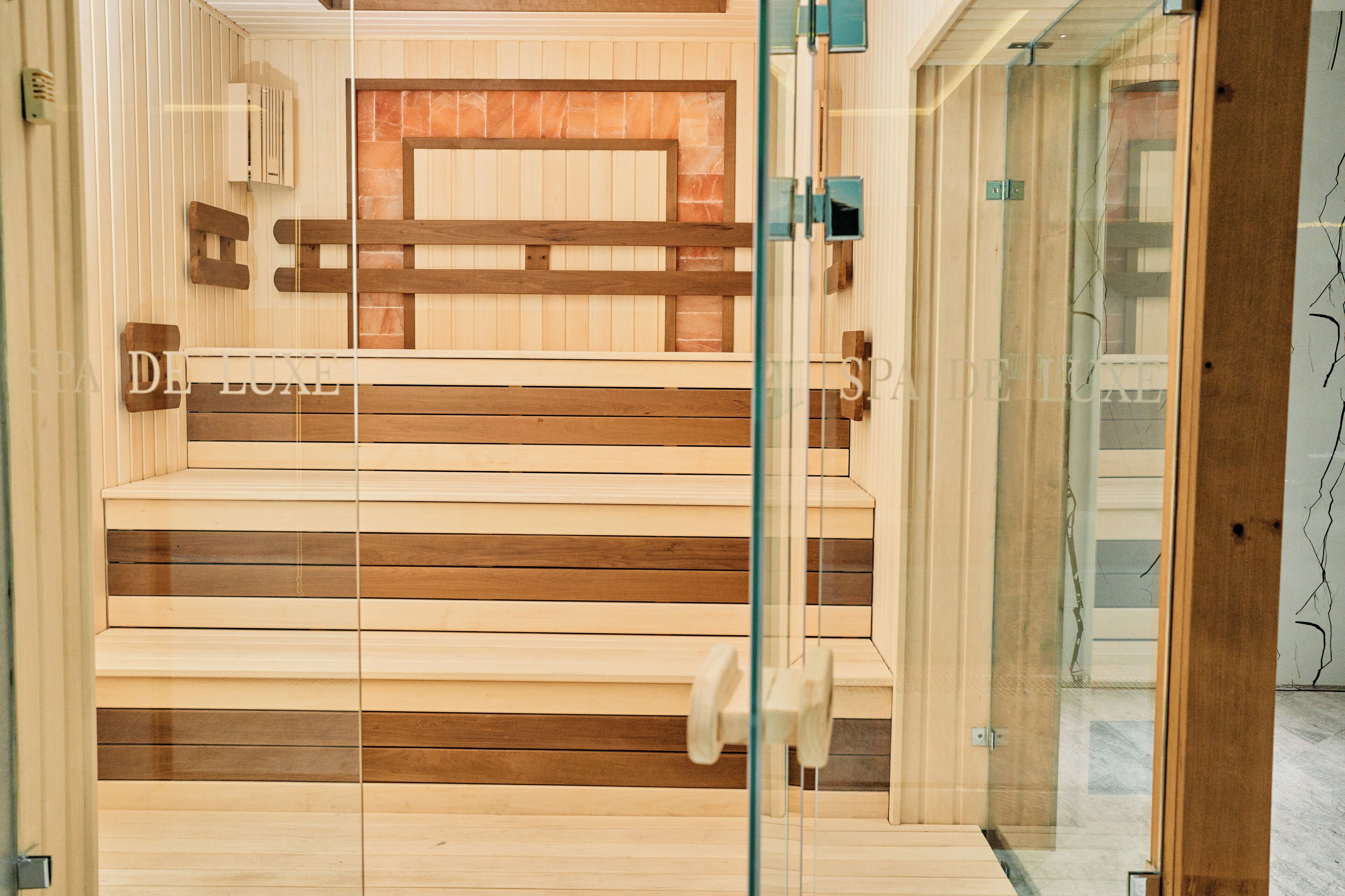 Interior de madera con un panel de vidrio, un banco y una puerta con picaporte.