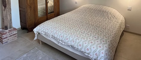 Ein Schlafzimmer mit einem Bett, einem Holzschrank und zwei Wandleuchten.
