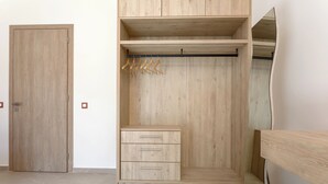 Un armadio in legno con appendiabiti e cassetti.