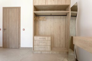 Ein Holzschrank mit Kleiderstange und Schubladen.