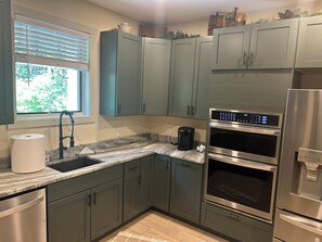 A kitchen with a built-in oven, a coffee maker, and a refrigerator. - Beautiful getaway at “Maggie Valley Resort” (Maggie Valley)