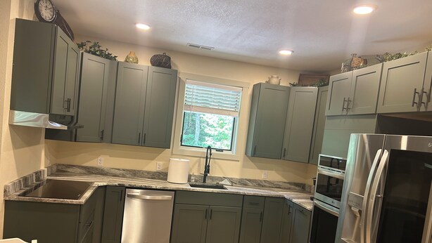 A modern kitchen with grey cabinets, a stainless steel dishwasher, a built-in oven, and a refrigerator. - Beautiful getaway at “Maggie Valley Resort” (Maggie Valley)