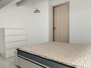Ein Schlafzimmer mit einem Bett, einem Kleiderschrank und einer Tür.