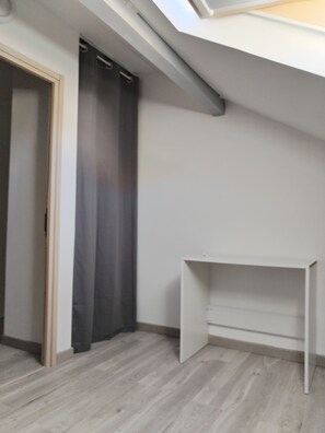 A room with a skylight, a door with a curtain, and a white desk. - Comfortable and well-equipped accommodations (Ville-la-Grand)