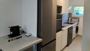A compact kitchen with a built-in refrigerator, microwave, and dishwasher. - Comfortable and well-equipped accommodations (Ville-la-Grand)